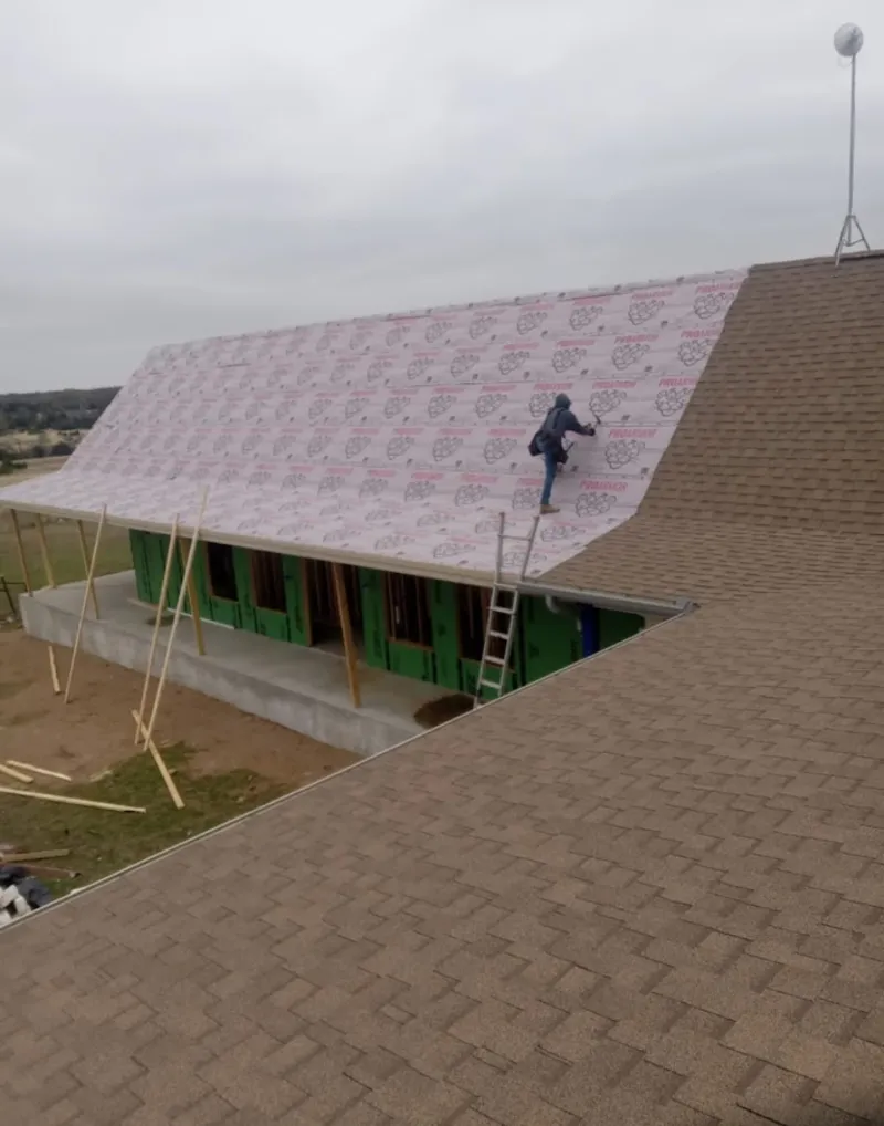 Worker preparing underlayment for a metal roof installation in Millsboro